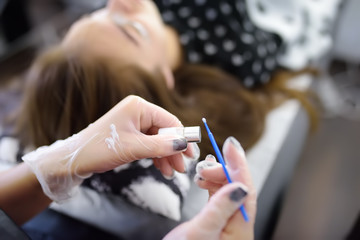 Beautician making eyelash lamination procedures. Modern eyelash care treatment procedures - staining, curling, laminating and extension for lashes.