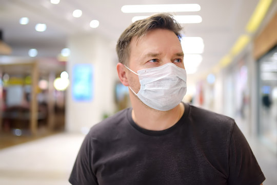 Man wearing disposable medical mask in airport or supermarket during coronavirus pneumonia outbreak