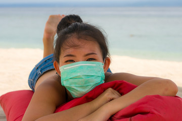 use of medical face mask in public places- young attractive Asian Korean woman enjoying beach...