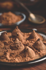 Homemade chocolate truffles coated in cocoa powder on metal tray