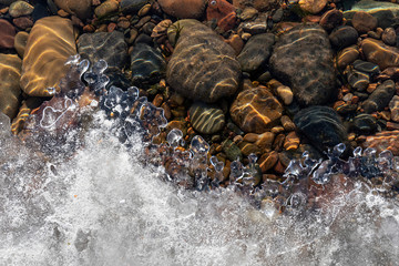 Spring background: curly edge of melting ice, clear river water