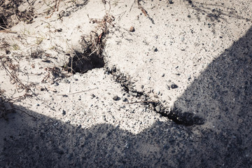 Small crack in the ground on the bank of the river due to water blur.
