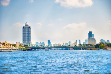 Cityscape view with Chao Phraya river, steel Memorial bridge and skyscrapers of downtown on background. Bangkok, Thailand