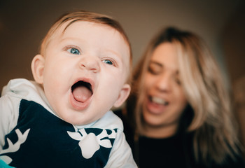 Happy baby laughing with his mother