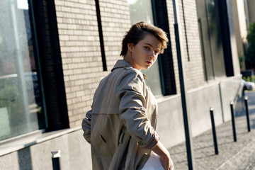 Pretty young girl woman teen girl wear smart casual trendy clothes trench coat walking down the...