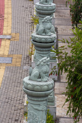 Fototapeta na wymiar Line of chinese mythical beast statues next to a brick footpath