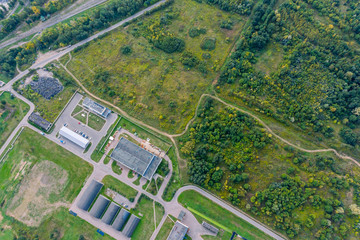 drone image of industrial area in city suburbs. manufacture companies and warehouses near forest