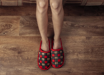 Top view of female bare legs with slippers on a wooden floor. Homeliness, Awakening