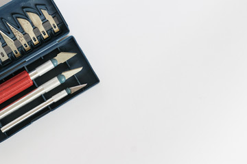 Tools for handmade, knives for cutting wood in a blue box on a gray background. Copyspace.