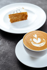 cup of coffee and cake on black stone background Top view