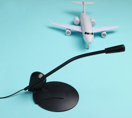 Air traffic controller, flight dispatcher. Plane figurine, microphone on blue background