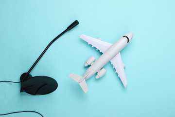 Air traffic controller, flight dispatcher. Plane figurine, microphone on blue background