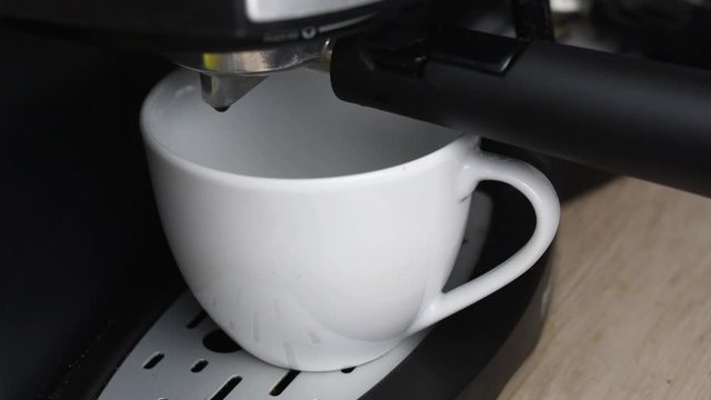 Exprimiendo caf&eacute; en una taza blanca
