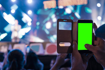 Hands of audience crowd people taking photo with mobile smart phone with green screen in party concert.