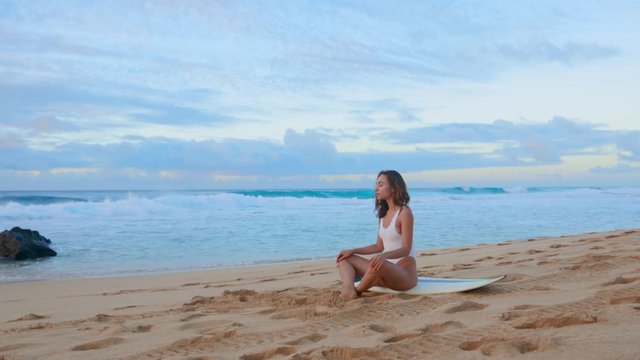 Surfer meditates at Hawaiian beach, calmness and concentration, readiness for a surfing session