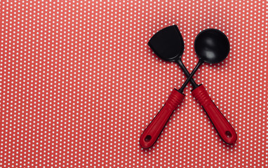 Toy kitchen tools on a polka dot tablecloth. Top view