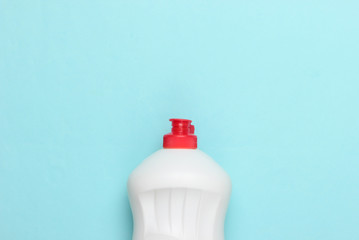 One bottle of detergent on blue pastel background. House cleaning concept. Minimalism. Top view.