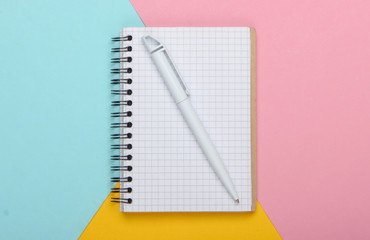 Notebook on pastel colored background. Top view