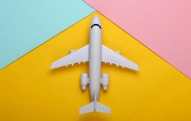 Toy model of plane on pastel background. The concept of tourism, air travel, minimalism. Top view