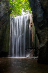 Fototapeta na wymiar waterfall in forest,bali waterfall cepung waterfall, beautiful wide waterfall that you stand in and that falls into a gorge