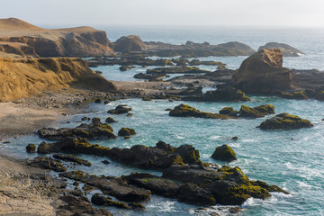 Fototapeta na wymiar Panoramic view of a rocky beach with green-blue seawater at Huarmey´s seaside in Ancash region, Peru
