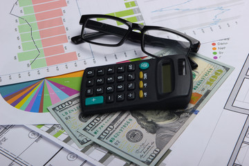 Classic eyeglasses, dollar bills, calculator with graphs and charts. Economic calculation, analytics, business concept.