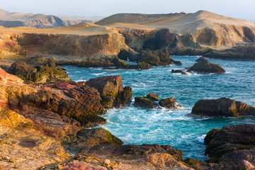 Rocky beach with  algaes and blue seawater at Huarmey´s seaside in Ancash region, Peru