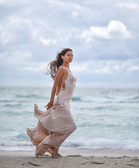 Fototapeta na wymiar lonely girl on the beach against a stormy sea