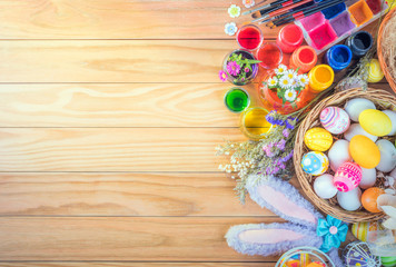 Obraz na płótnie Canvas Happy Easter day colorful eggs and flower a set of food coloring, acrylic paintbrush for do it yourself on brown wooden floor with copy space