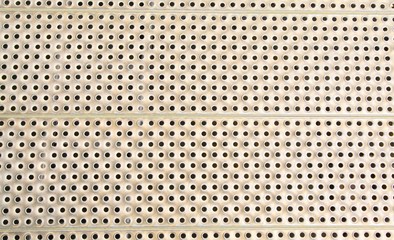 Metal plate with many circular holes background.