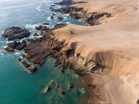 Aerial view of a rocky beach with green-blue seawater at Huarmey&acute;s seaside in Ancash region, Peru