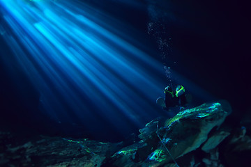 underwater world cave of yucatan cenote, dark landscape of stalactites underground, diver