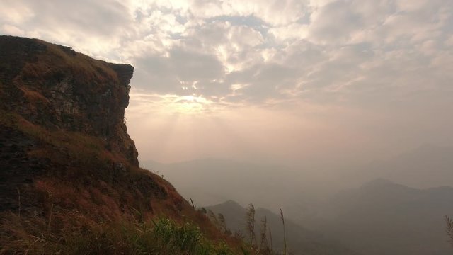 Time lapse of beautiful sunrise at Phu Chi Fah National Park, A tourist destination on a hilltop during the foggy and beautiful light in the morning and sunset in Chiang Rai Thailand 