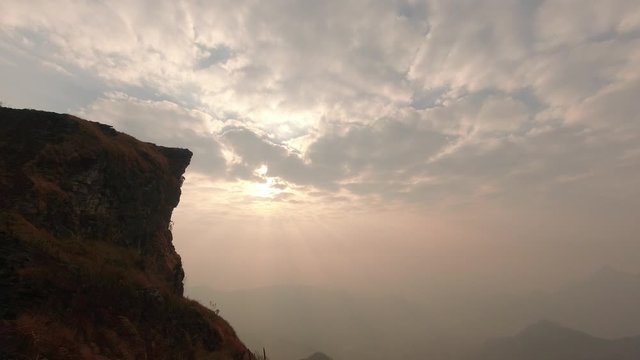 Time lapse of beautiful sunrise at Phu Chi Fah National Park, A tourist destination on a hilltop during the foggy and beautiful light in the morning and sunset in Chiang Rai Thailand 