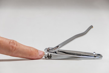 Finger prepare to cutting from old Nail clippers with white background