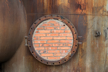 Closed metal tank with brick wall