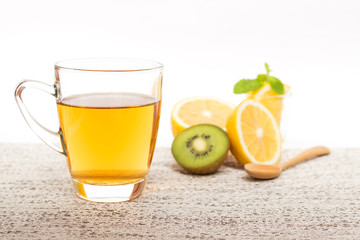 Glass cup of organic fruit tea on gentle background.