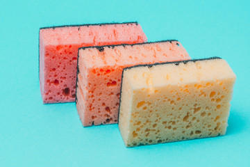 Sponges for washing and cleaning multicolored on blue background.