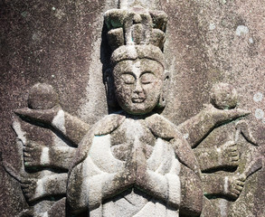 Fototapeta na wymiar Stone Buddhist statue of a Thousand Armed Kannon in Japan