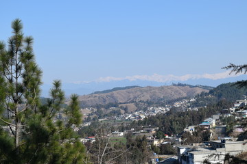 Beautiful view of snow covered mountain and homes in bright sunny day with clear blue sky