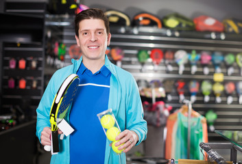 male holding new rocket and balls for padel