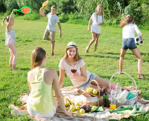 Two young mums enjoying picnic outdoors