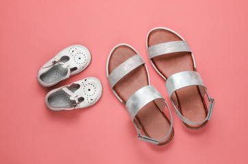 Kids and adults fashionable sandals on pink background. Top view