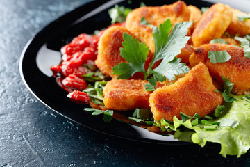  Fried chicken nuggets with ketchup, sprinkled with chopped parsley.