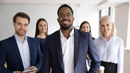 Group portrait of smiling motivated multiracial businesspeople stand show unity and support, happy...