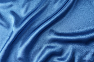 Fototapeta na wymiar Blue silk background with a folds. Abstract texture of rippled satin surface