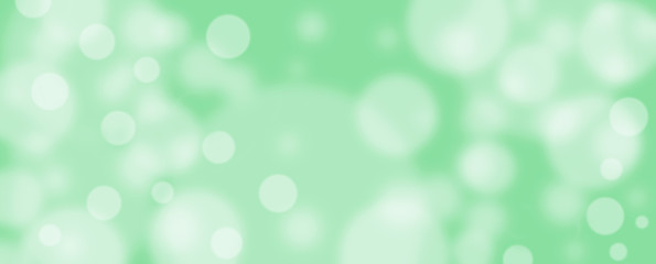 Abstract green bokeh banner background - birthday, father's day, valentine's day panorama - blurry bokeh circles on a green background. Christmas or spring concept