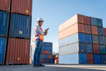Logistics engineer control at the port, loading containers for trucks  export and importing...