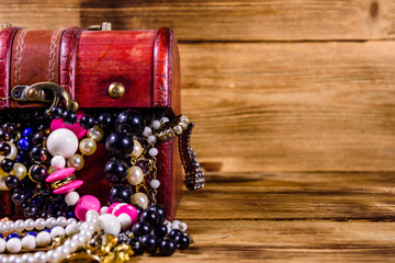 Old box of red wood full of the jewelry. Treasure chest
