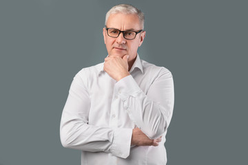 Senior pensive man portrait on gray background